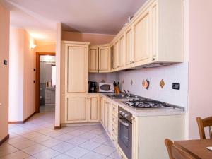 a kitchen with white cabinets and a stove top oven at Apartment Martino - DMA321 by Interhome in Vercana +17 photos