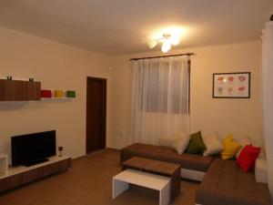 a living room with a couch and a tv at Summer Breeze Villa in Balchik