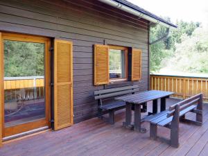 une terrasse en bois avec deux bancs et une table dans l'établissement Chalet Fischerhütte - STN100 by Interhome, à Sankt Nikolai im Sölktal