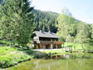 una casa grande junto a un río con árboles en Chalet Fischerhütte - STN100 by Interhome, en Sankt Nikolai im Sölktal