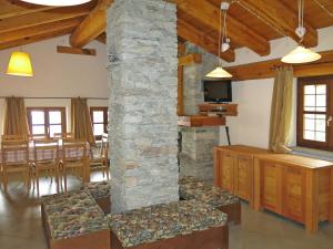 a living room with a stone fireplace and a dining room at Chalet Casot Brusa - SMY101 by Interhome in Sampeire