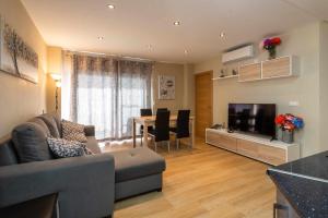 Sala de estar con sofá, TV y mesa en Apartamento Las Góndolas Playa ALOJAMIENTOS VISTAMAR, en Almuñécar