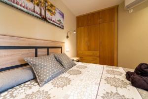 ein Schlafzimmer mit einem Bett mit einem hölzernen Kopfteil in der Unterkunft Apartamento Las Góndolas Playa ALOJAMIENTOS VISTAMAR in Almuñécar + 40 Fotos