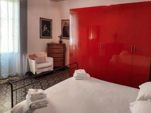 a bedroom with red cabinets and a bed and a chair at Apartment Lancillotto - FLG215 by Interhome in Finale Ligure