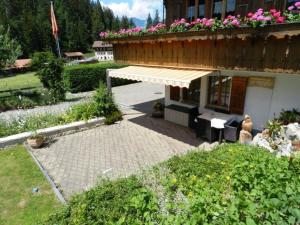 a building with a balcony with pink flowers on it at Apartment Giferblick by Interhome in Zweisimmen