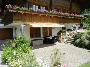 a building with a patio with flowers on it at Apartment Giferblick by Interhome in Zweisimmen