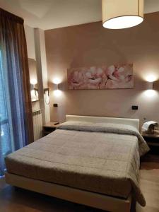 a bedroom with a bed and a painting on the wall at Hotel Il boschetto in Tolentino