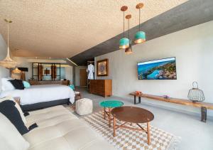 a bedroom with a bed and a living room at Mvngata Beach Hotel in Playa del Carmen