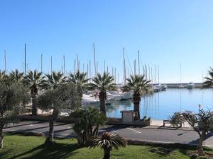 a view of a marina with palm trees and water at Apartment Marta by Interhome in Terzorio