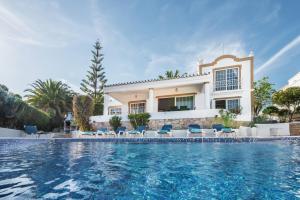 une villa avec piscine devant une maison dans l'établissement Buganvilia by Algarve Villa Holidays, à Guia