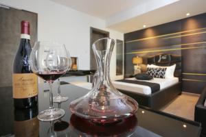 a bottle of wine and two glasses on a table in a room at J'Me Boutique Hotel - Adults only in St. Julianʼs