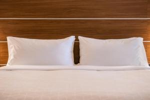 1 cama con 2 almohadas blancas y cabecero de madera en Holiday Inn Express Hotel & Suites Gunnison, an IHG Hotel en Gunnison
