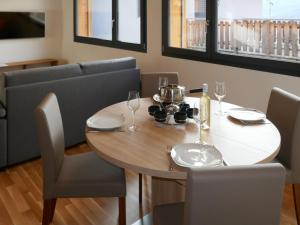 mesa de comedor con sillas y mesa de madera con copas de vino en Chalet Le Raccard by Interhome, en Savièse