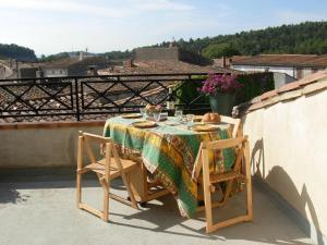 a table with a table cloth and two chairs on a balcony at gite le musee in Villeneuve-Minervois