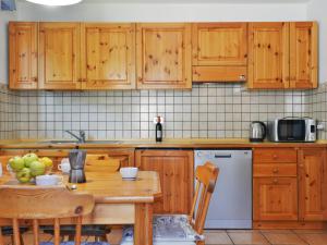 a kitchen with wooden cabinets and a wooden table at Apartment Apt 3 by Interhome in Canazei