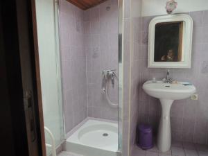 a pink tiled bathroom with a sink and a shower at gite le musee in Villeneuve-Minervois