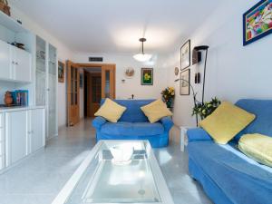 a living room with blue couches and a glass table at Apartment Els Pins Maria by Interhome in Torredembarra