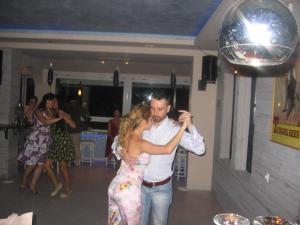 a man and a woman dancing at a party at Karaoulanis Beach in Agios Ioannis Pelio