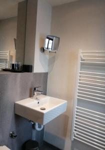 ein Badezimmer mit einem weißen Waschbecken und einem Spiegel in der Unterkunft Landhaus Lindner Appartements in Fügen