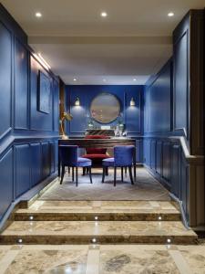 une salle à manger avec des murs bleus, une table et des chaises dans l'établissement Flemings Mayfair - Small Luxury Hotel of the World, à Londres