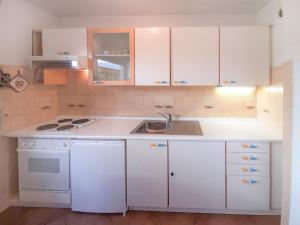 a kitchen with white cabinets and a sink at Apartment Roacia-2 by Interhome in Alba di Canazei