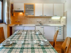 a kitchen with a table with plates and bowls on it at Apartment Roacia-2 by Interhome in Alba di Canazei