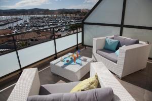 a balcony with chairs and a table and a view of a harbor at Hôtel Baptistin in Le Lavandou