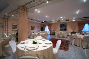 a banquet hall with white tables and white chairs at Hotel Giardino in San Lorenzo in Campo