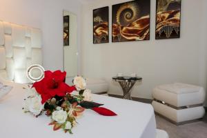 a room with a white table with flowers on it at J'Me Boutique Hotel - Adults only in St. Julianʼs