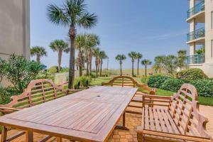 a wooden picnic table with benches and palm trees at Jade East Towers 720 in Destin