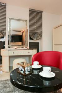 a living room with a table and a red chair at J'Me Boutique Hotel - Adults only in St. Julianʼs