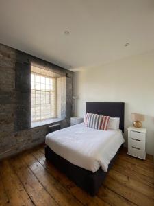 a bedroom with a large bed and a window at Buckingham Place at the Royal William Yard in Plymouth