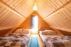 a bedroom with two beds in a wooden attic at Marina in Jarosławiec