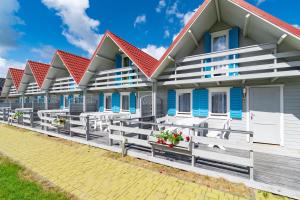a row of blue and white houses with red roofs at Marina in Jarosławiec