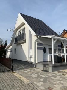 a white house with a balcony and a patio at Rita Apartmanház in Bük