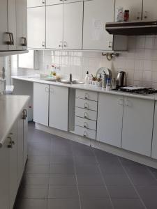 a white kitchen with white counters and white cabinets at Rose view guest house in Lisbon