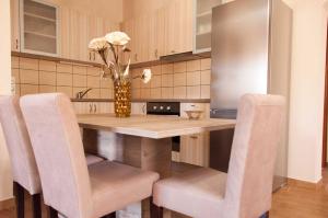 a kitchen with a table with chairs and a vase with flowers at Soureto's House in Liapades