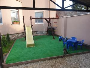 a playground with a slide and a table and chairs at Anda vendégház in Harkány