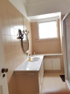 a bathroom with a sink and a mirror and a window at Rose view guest house in Lisbon