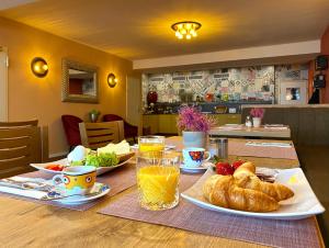 a table with a breakfast of croissants and orange juice at Rußmann Hotel & Living in Goldbach