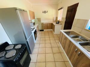 uma cozinha com um frigorífico e um lavatório em Ithonsi Guesthouse and Spa em Kempton Park