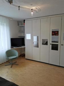 a living room with a large white cabinet and a chair at Ferienwohnung und B&B Chasa Janett in Rudolfstetten