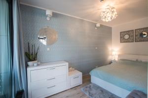 sypialnia z łóżkiem, komodą i lustrem w obiekcie Apartament Unia 12 Basen&SPA w mieście Lublin
