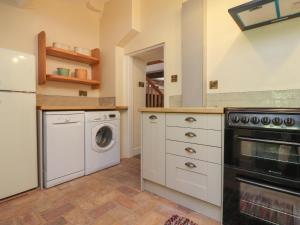 a kitchen with a washing machine and a washer and dryer at Sunny Bank in Lancaster