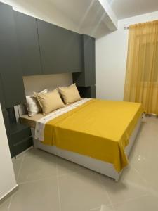 Schlafzimmer mit einem Bett mit gelber Bettwäsche und Kissen in der Unterkunft Brankooo in Bar