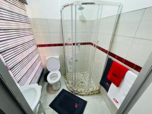 a small bathroom with a shower and a toilet at Ithonsi Guesthouse in Kempton Park +25 photos