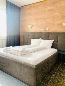 a bedroom with a large bed with a wooden wall at ArdoSpa Hotel and Restaurant in Sarnitsa