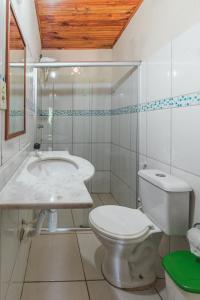 Baño blanco con aseo y lavamanos en Pousada La Cabana, en Itacaré