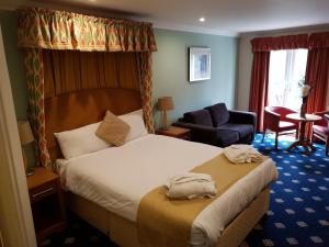 a hotel room with a bed and a chair at Kegworth Hotel & Conference Centre in Castle Donington