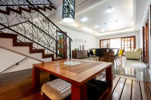 a living room with a wooden table and a staircase at Casa Completa Campinas in Campinas